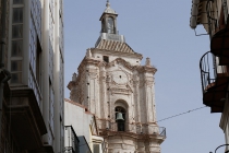 Spitze eines Kirchturms der zwischen Häusern durch scheint